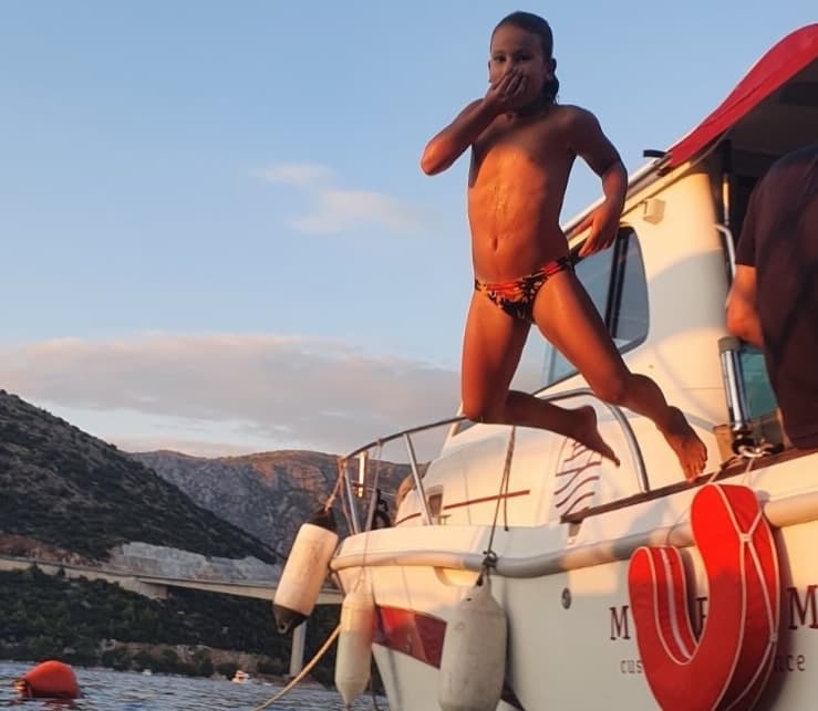 Junge springt vom Boot ins Meer